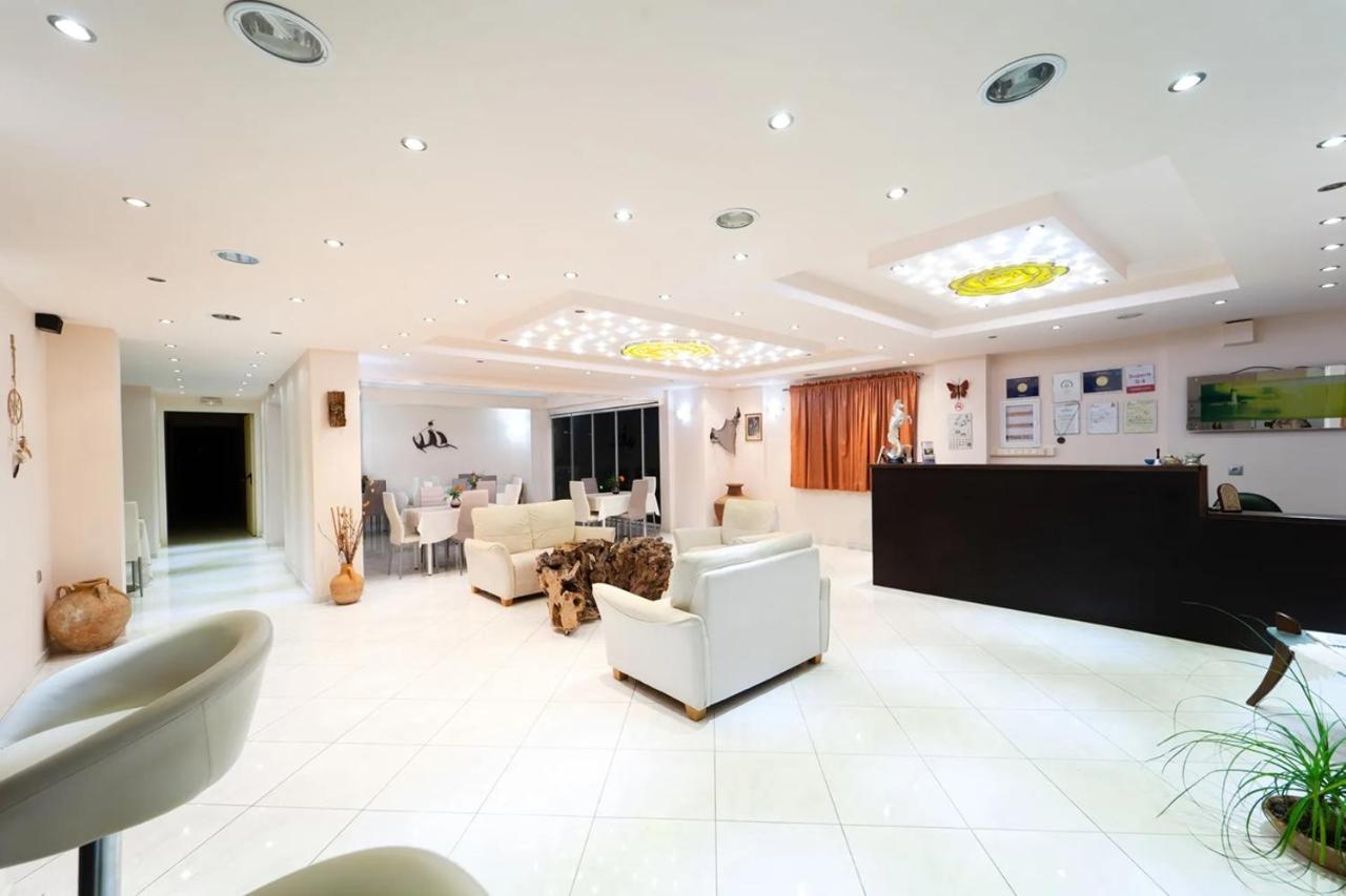 een grote kamer met een hal met wit meubilair bij Golden Rose Suites in Kolymvari
