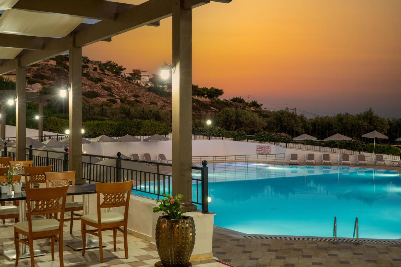 een hotelterras met een zwembad bij zonsondergang bij Mare Village in Ierápetra