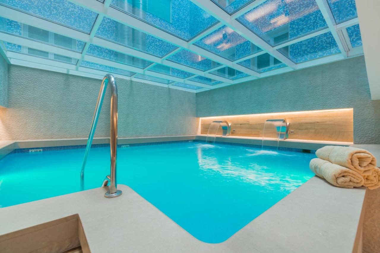 een zwembad met blauw water in een gebouw bij Sallés Hotel Pere IV in Barcelona