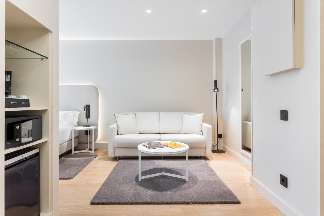 een woonkamer met een witte bank en een tafel bij Hotel Royal Ramblas in Barcelona