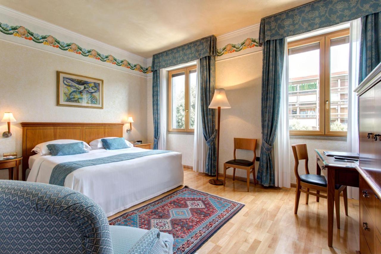 een hotelkamer met een bed en een bureau bij Ferretti Hotel Firenze in Verona