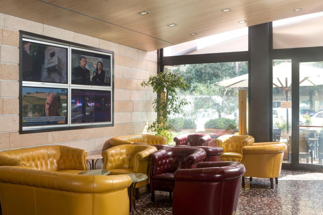 een lobby met leren banken, tafels en stoelen bij Ferretti Hotel Firenze in Verona