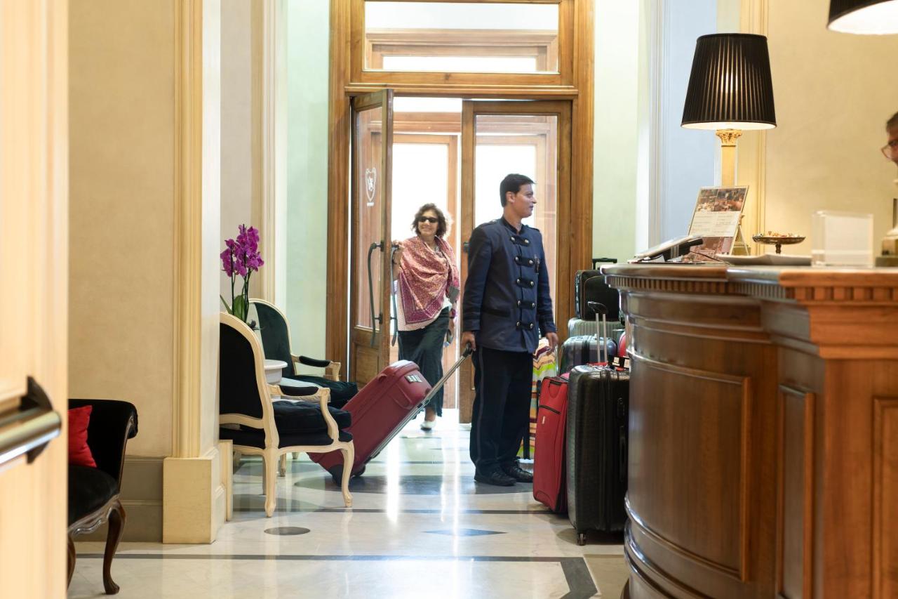 Een man en een vrouw staan met bagage in een gang. bij Alpi Hotel in Rome