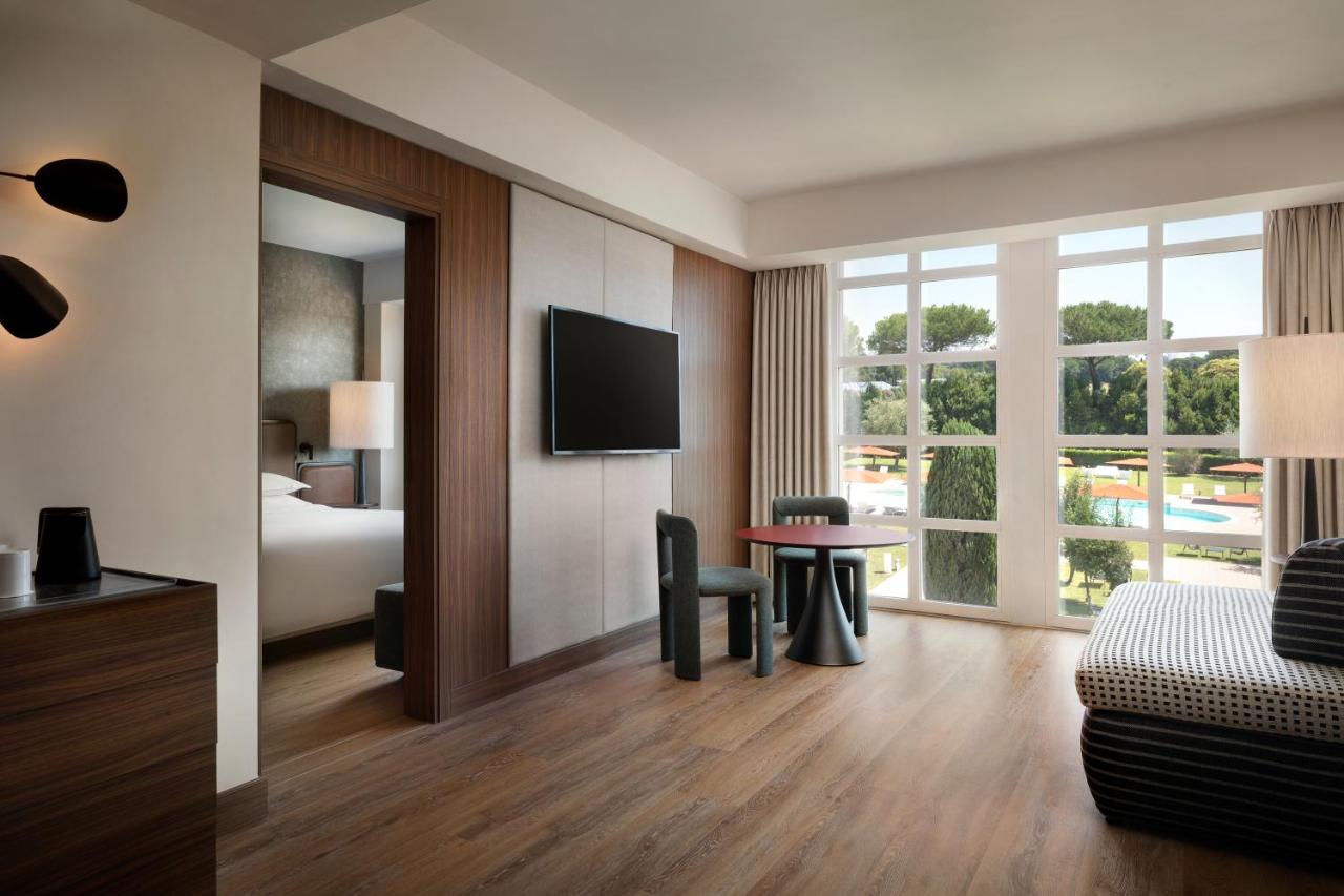 een hotelkamer met een bed en een bureau met een tafel bij Sheraton Rome Parco de Medici in Rome