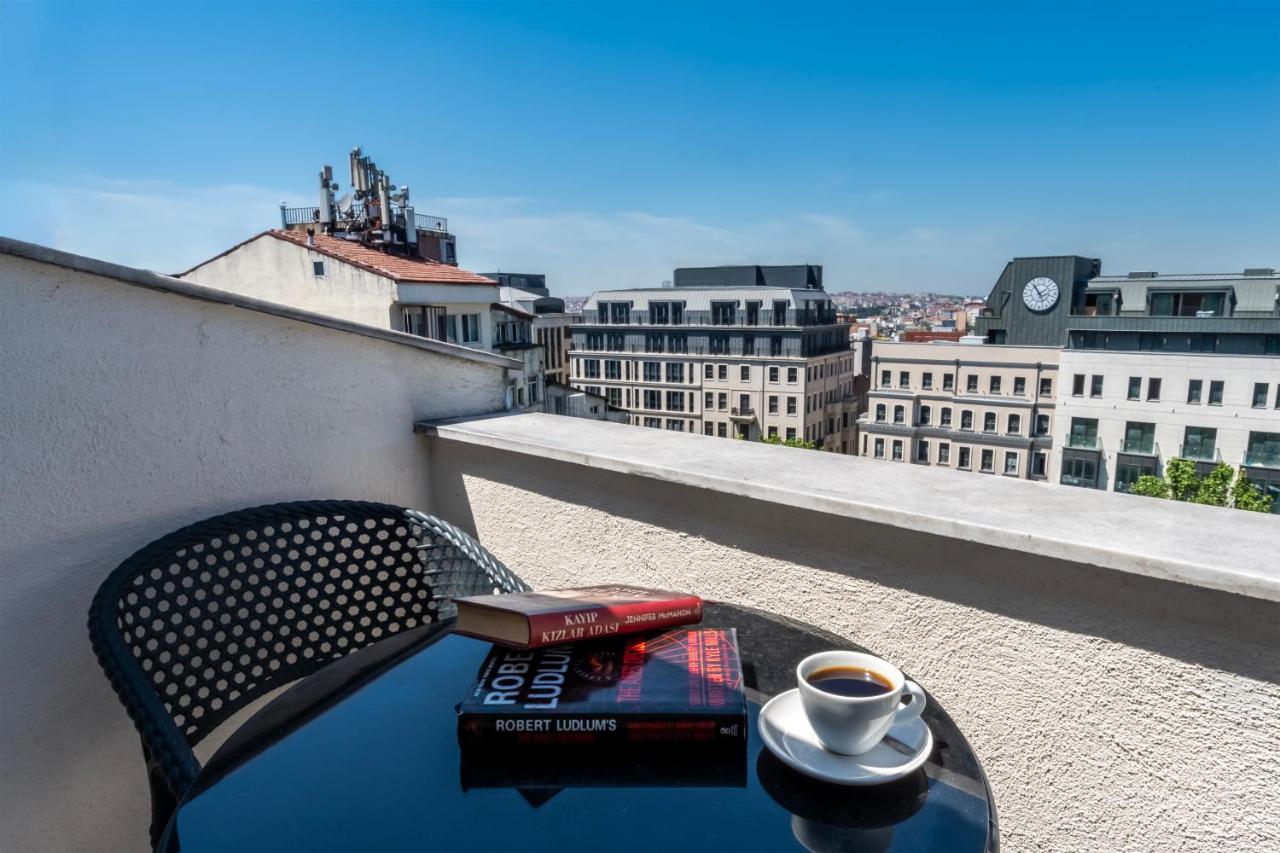 een tafeltje met een boek en een kop koffie op een balkon bij Taksim Trust Hotel in Istanbul