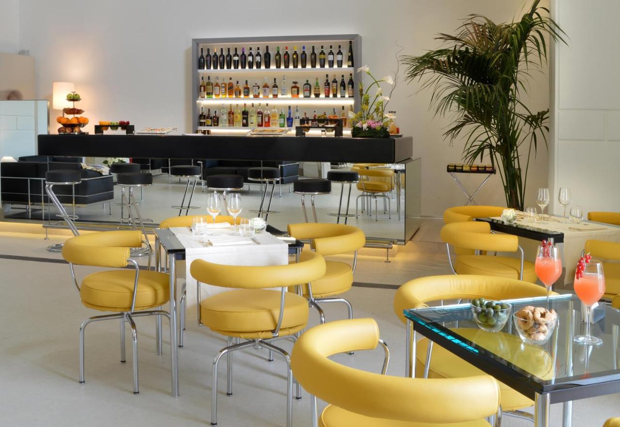 een restaurant met gele stoelen en tafels en een bar bij Palazzo Esedra in Napels