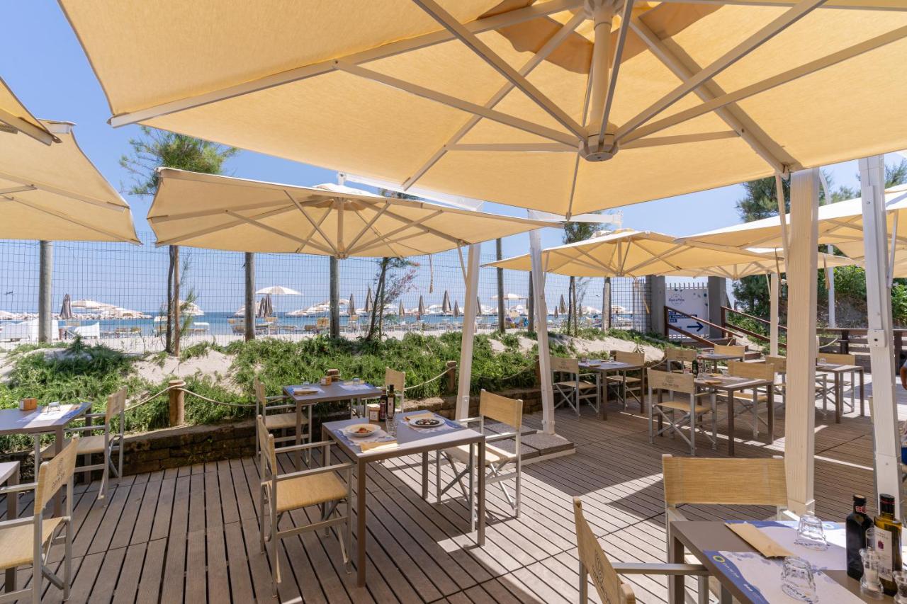 een restaurant met tafels en parasols op een terras bij Club del Sole Vigna sul Mar Family Collection in Lido di Pomposa