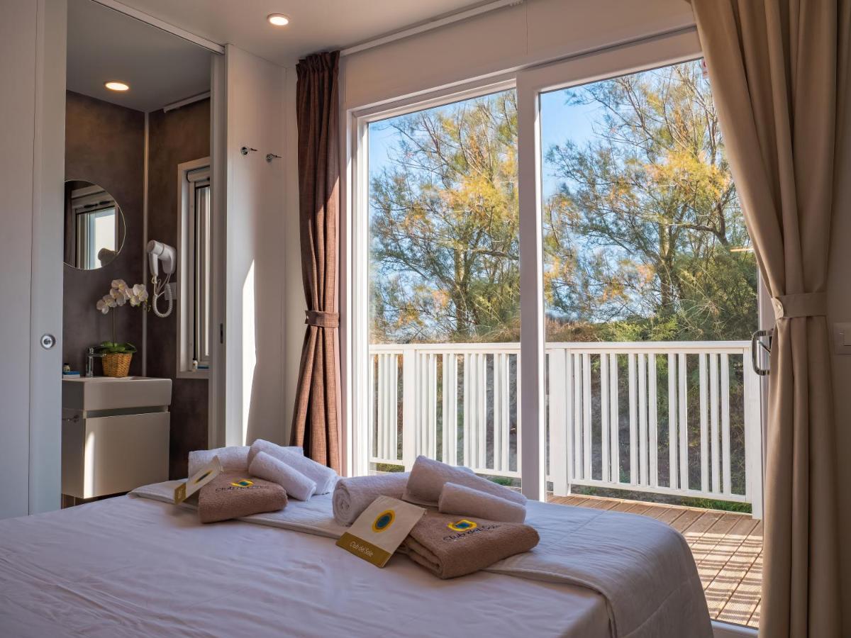 een slaapkamer met een bed en een groot raam bij Club del Sole Vigna sul Mar Family Collection in Lido di Pomposa +191 f