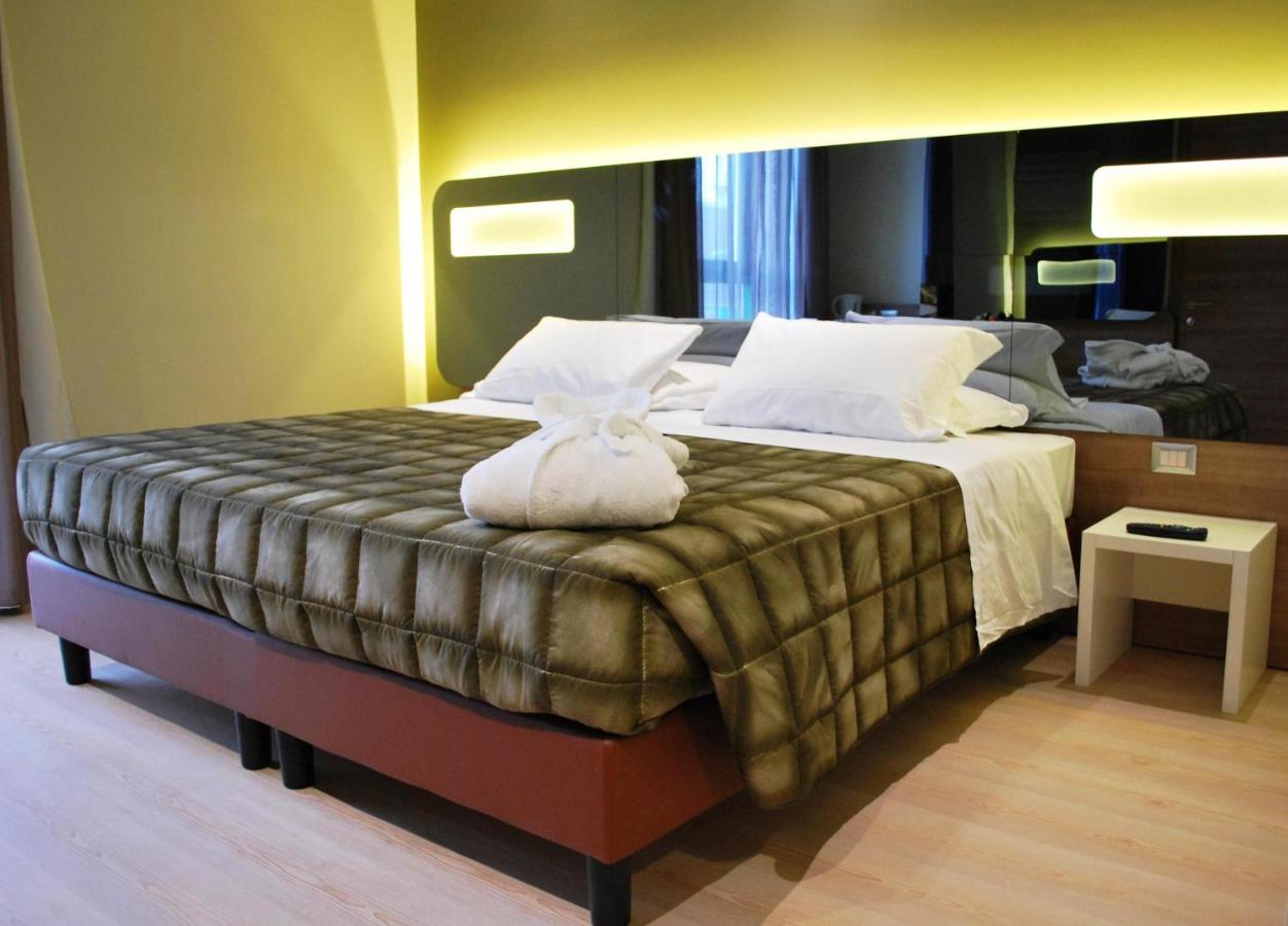 een slaapkamer met een groot bed met witte kussens bij Idea Hotel Plus Savona in Savona