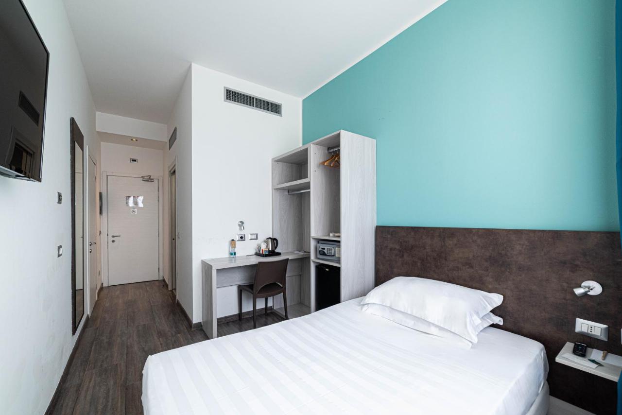 een slaapkamer met een bed en een bureau erin bij Phi Hotel Milano in Baranzate