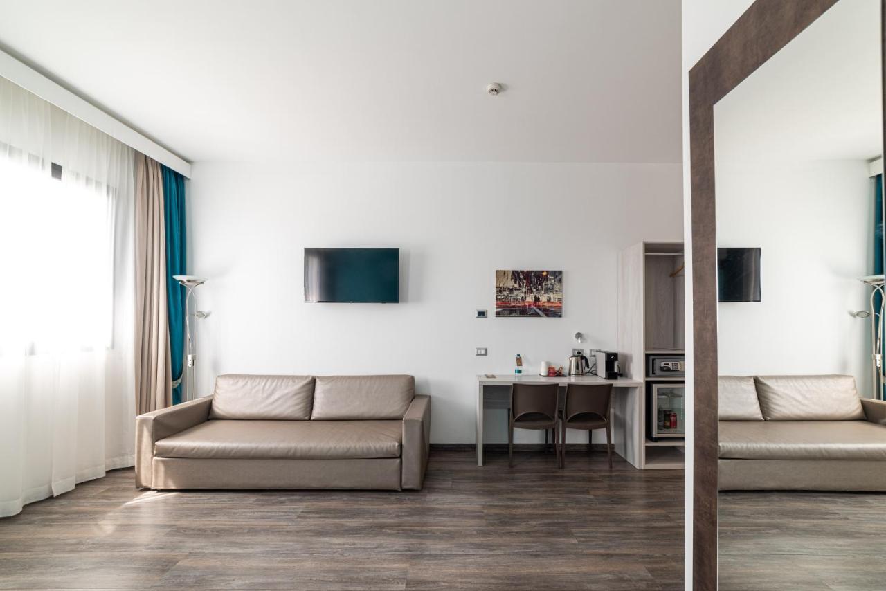 een woonkamer met een bank en een tafel bij Phi Hotel Milano in Baranzate