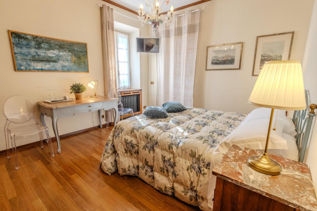 een slaapkamer met een bed, een bureau en een lamp bij Villa La Meridiana in Alba