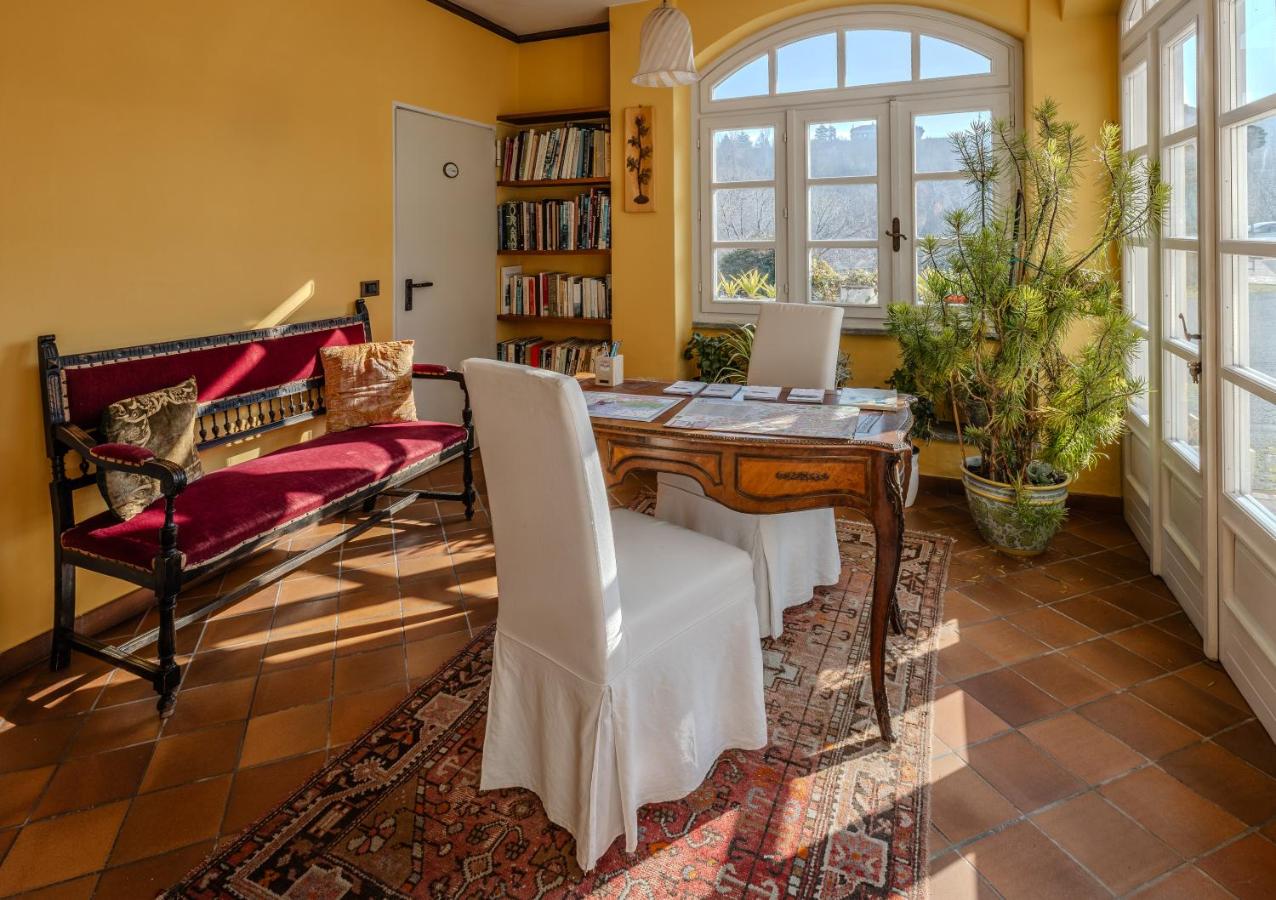 een eetkamer met een houten tafel en witte stoelen bij Villa La Meridiana in Alba