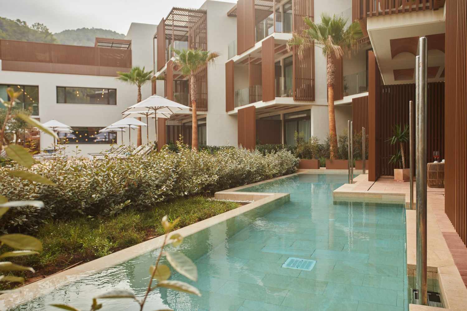 Zwembad omringd door palmbomen — The Club Cala San Miguel Hotel Ibiza, Curio Collection by Hilton