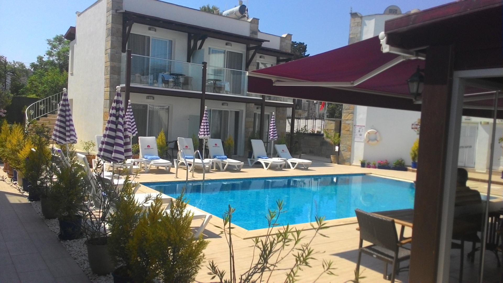 Buitenzwembad met ligbedden — Cotton Boutique Hotel