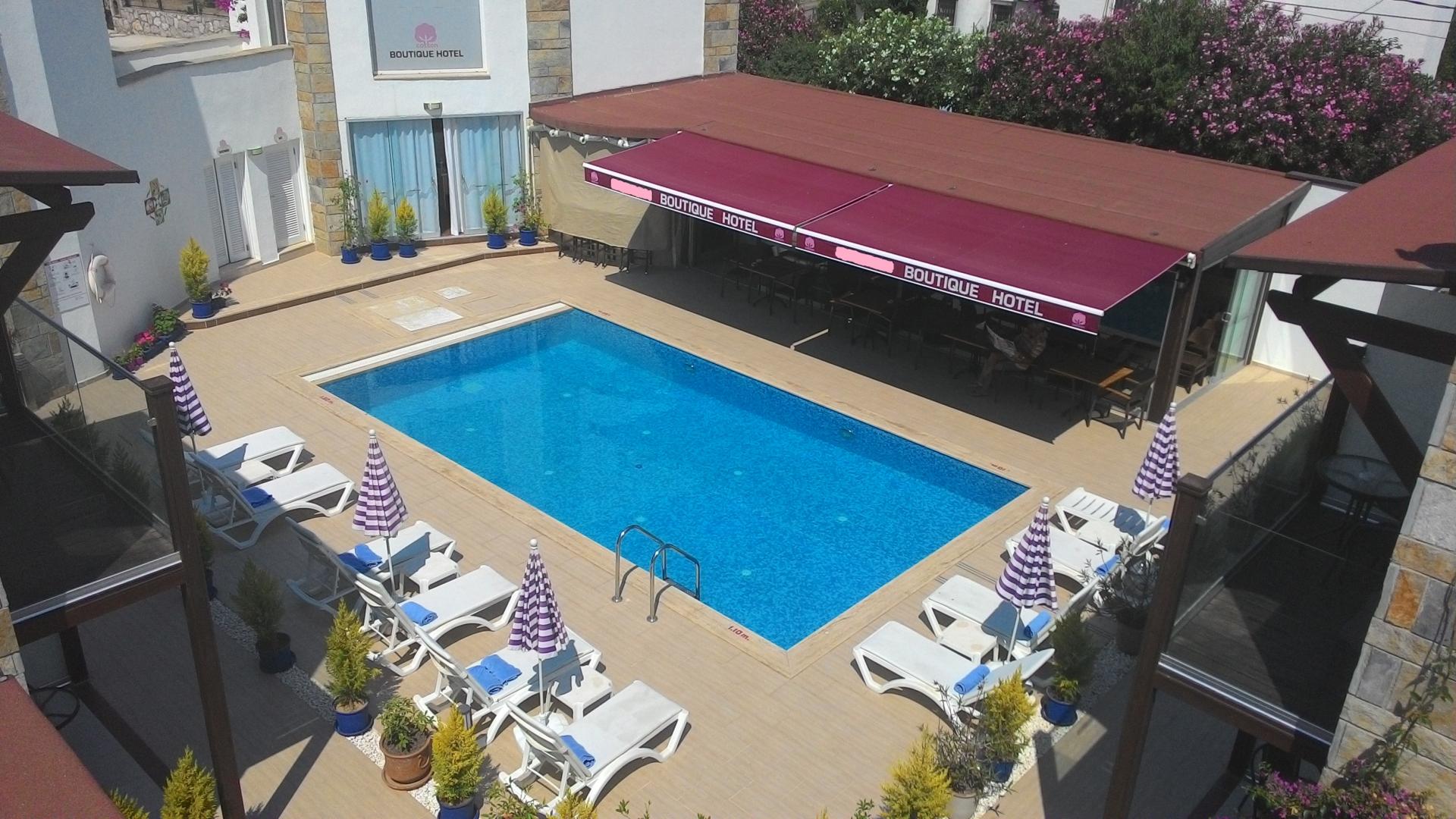 Buitenzwembad met ligbedden — Cotton Boutique Hotel
