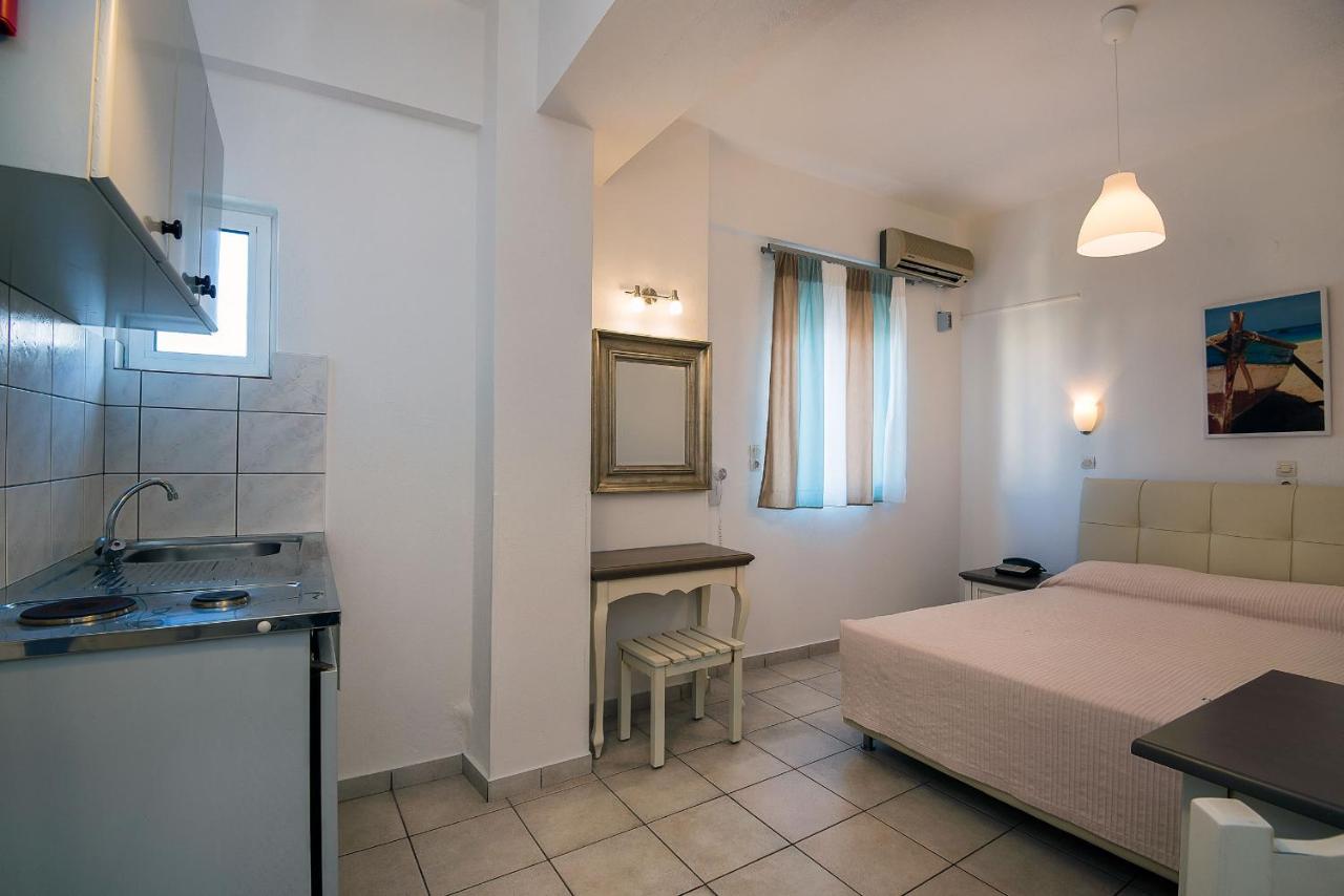 een kleine kamer met een bed en een wastafel erin bij Diamond Apartments & Suites in Chersonissos