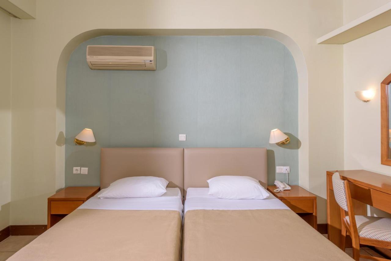 een slaapkamer met twee bedden en een airconditioning bij El Greco Hotel in Heraklion