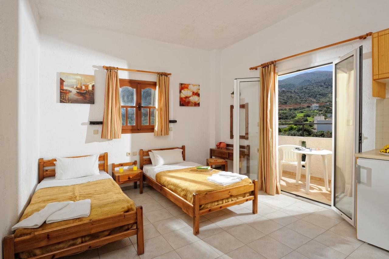 een slaapkamer met twee bedden en een balkon bij Stelios Residence Apartments in Malia