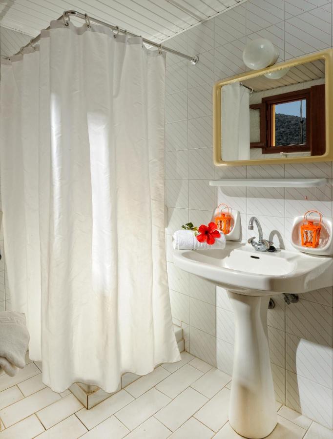 een badkamer met een wit douchegordijn en een wastafel bij Stelios Residence Apartments in Malia