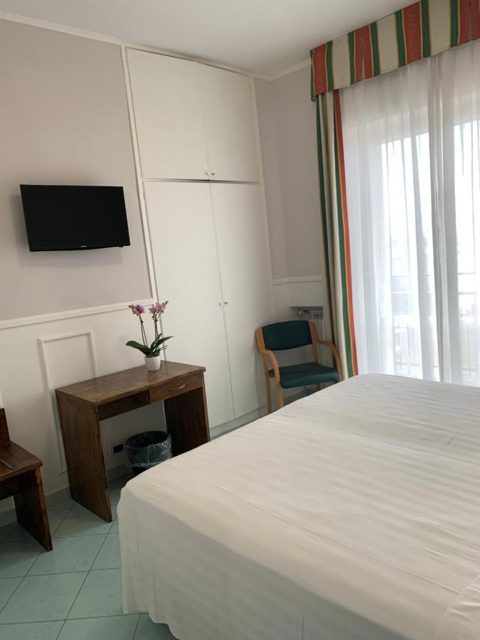 een slaapkamer met een bed en een tv aan de muur bij Hotel Conte in Ischia Town