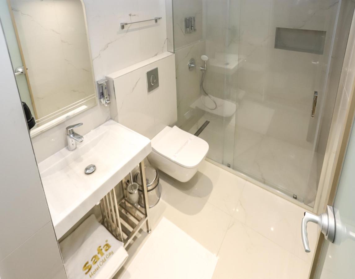 een witte badkamer met een toilet en een douche bij Safa Hotel Old City in Istanbul