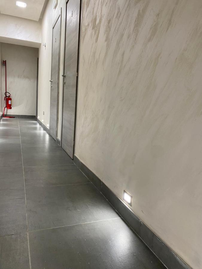 een lege gang met een betonnen muur met deuren bij Hotel Poker in Napels