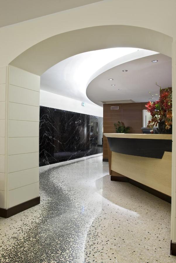 een kantoorlobby met een gepolijste betonnen vloer en een wit plafond bij Hotel Memphis in Rome