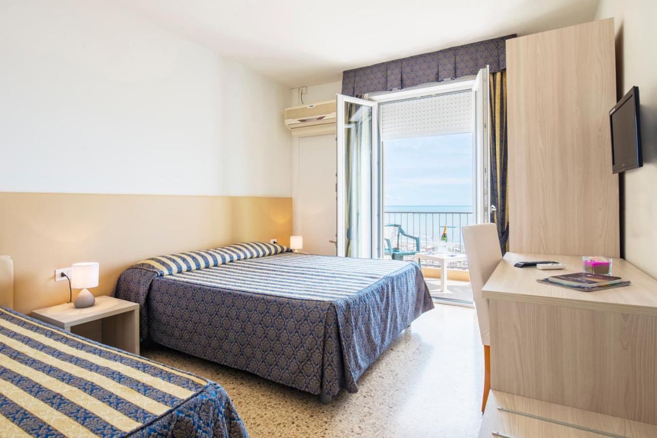 een hotelkamer met twee bedden en een balkon bij Hotel Columbus in Caorle