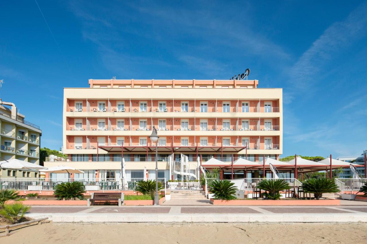 een hotelgebouw met een strand ervoor bij Hotel Columbus in Caorle