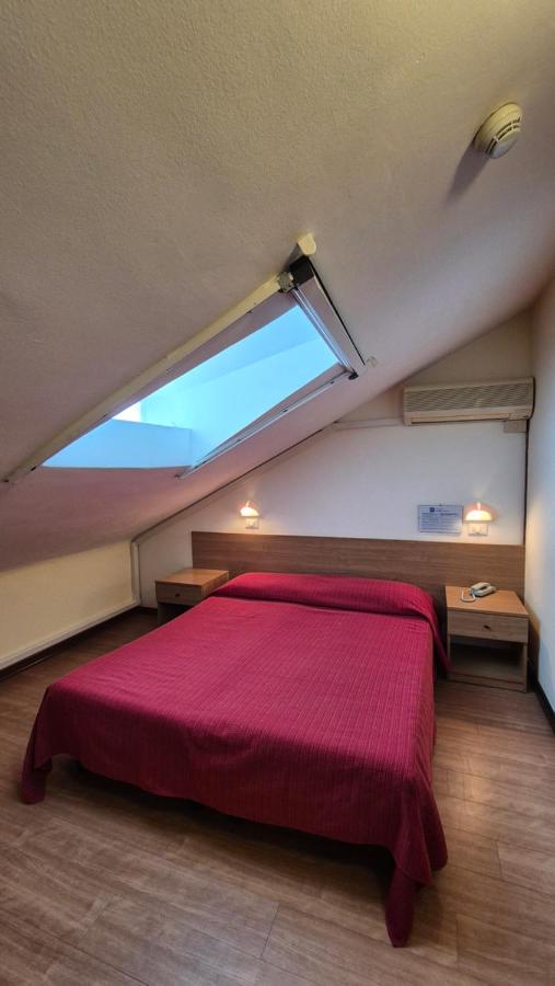 een slaapkamer met een groot rood bed en een raam bij Al Cavallino Bianco in Lignano Sabbiadoro