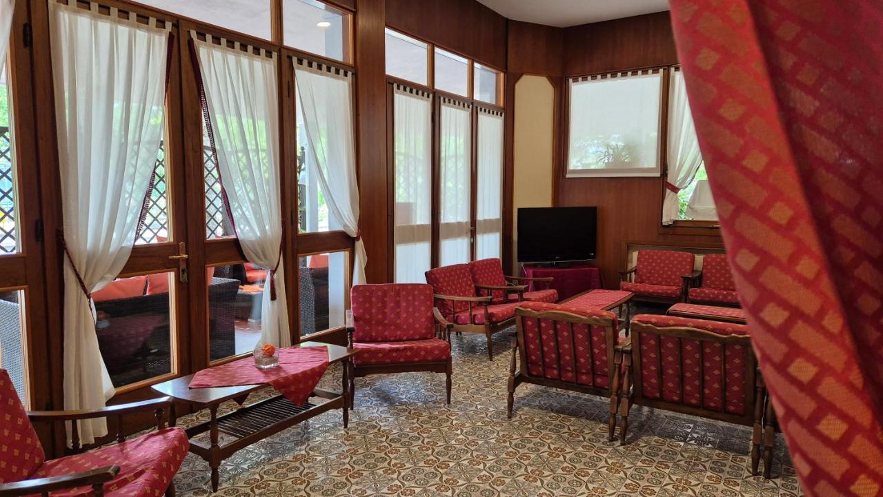 een wachtkamer met stoelen, een tv en ramen bij Al Cavallino Bianco in Lignano Sabbiadoro