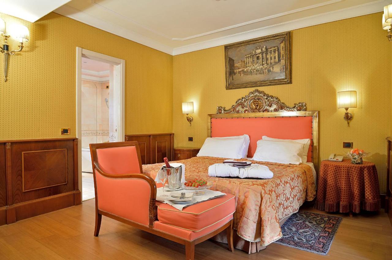een slaapkamer met een bed, een tafel en een stoel bij Hotel Homs in Rome