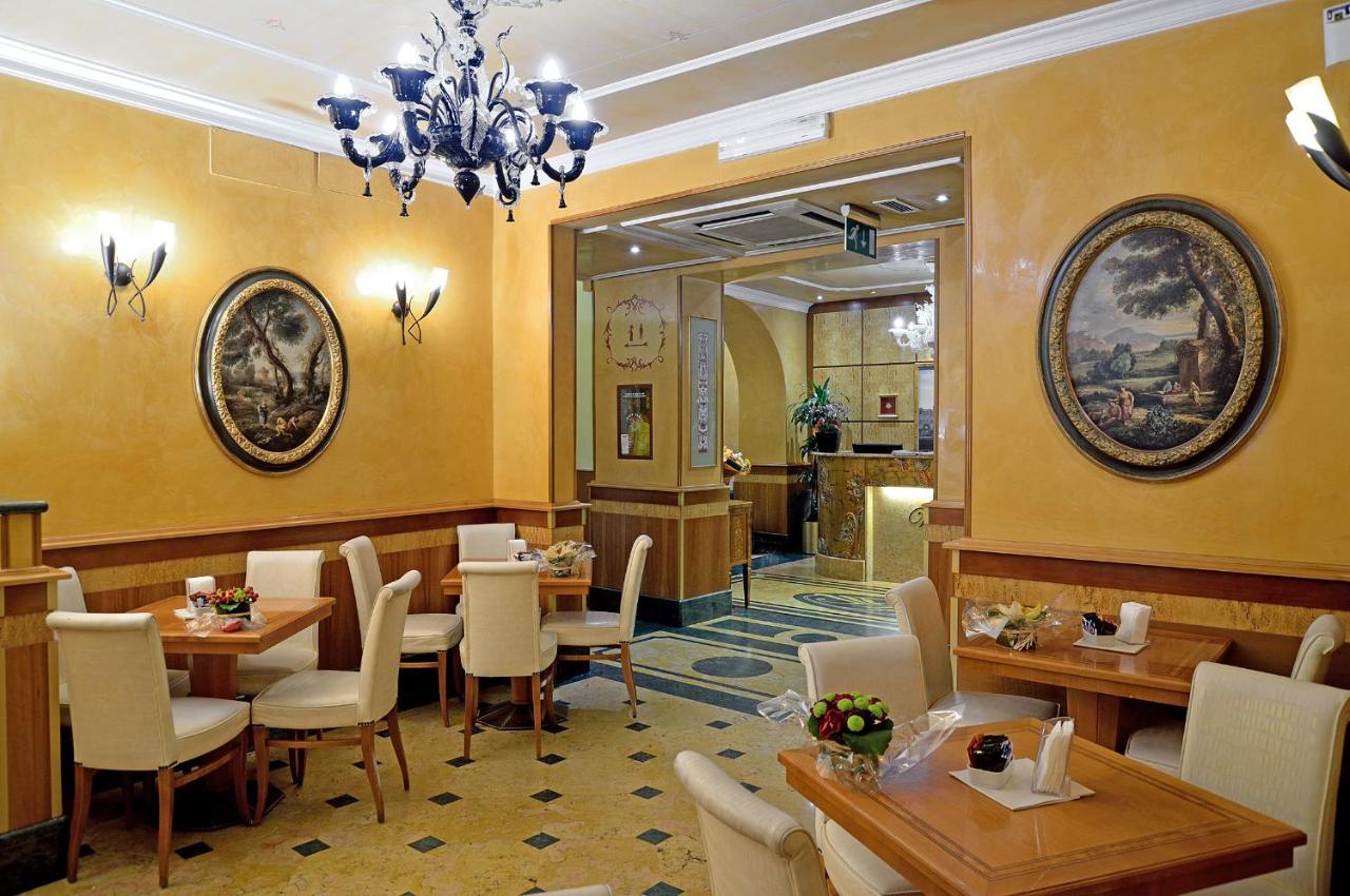 een restaurant met tafels en stoelen en een kroonluchter bij Hotel Homs in Rome