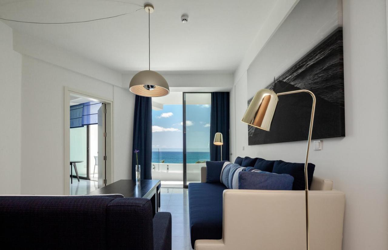 een woonkamer met een blauwe bank en een tafel bij Almyra in Paphos City