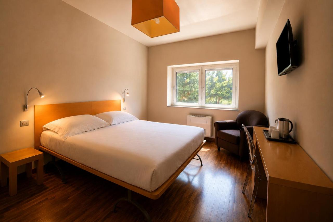 een slaapkamer met een bed, een bureau en een raam bij San Lorenzo Si Alberga in Camigliatello Silano