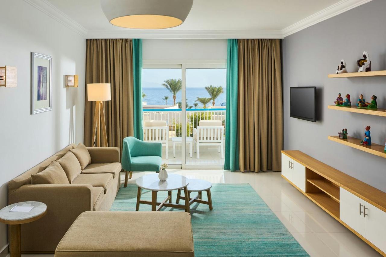 een woonkamer met een bank en een tafel bij Renaissance Sharm El Sheikh Golden View Beach Resort in Sharm El Sheikh +99 
