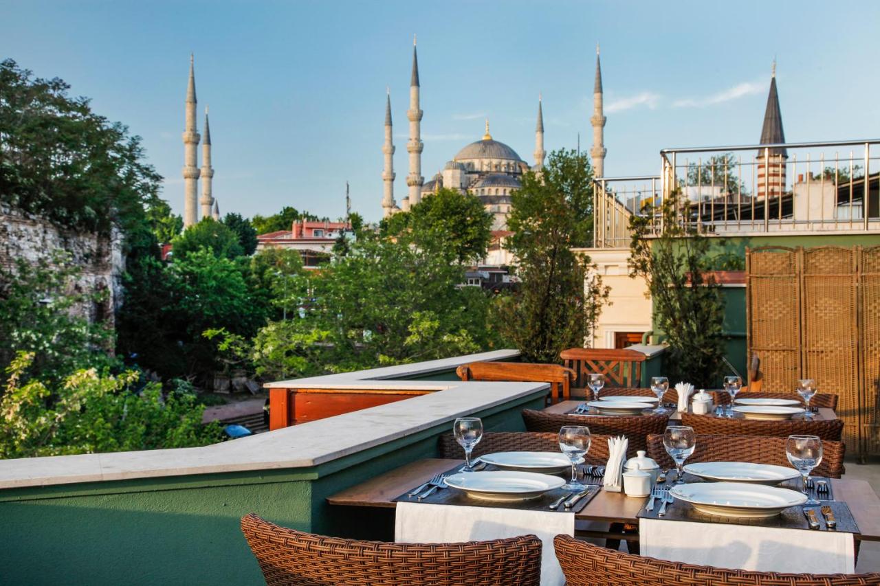een patio met tafels en stoelen met uitzicht op de moskee bij Hotel Erguvan - Special Category in Istanbul