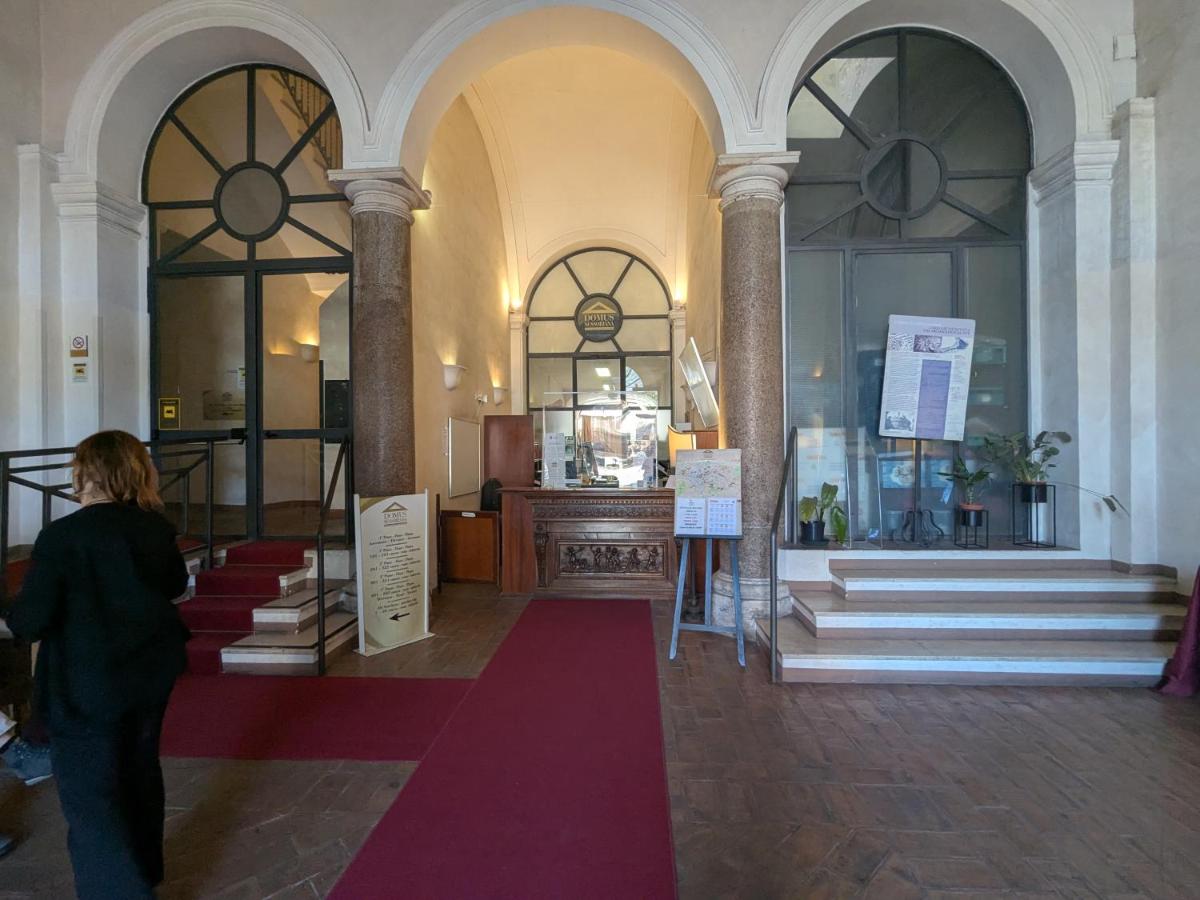 een vrouw die door een gebouw loopt met een rode loper bij Domus Sessoriana in Rome