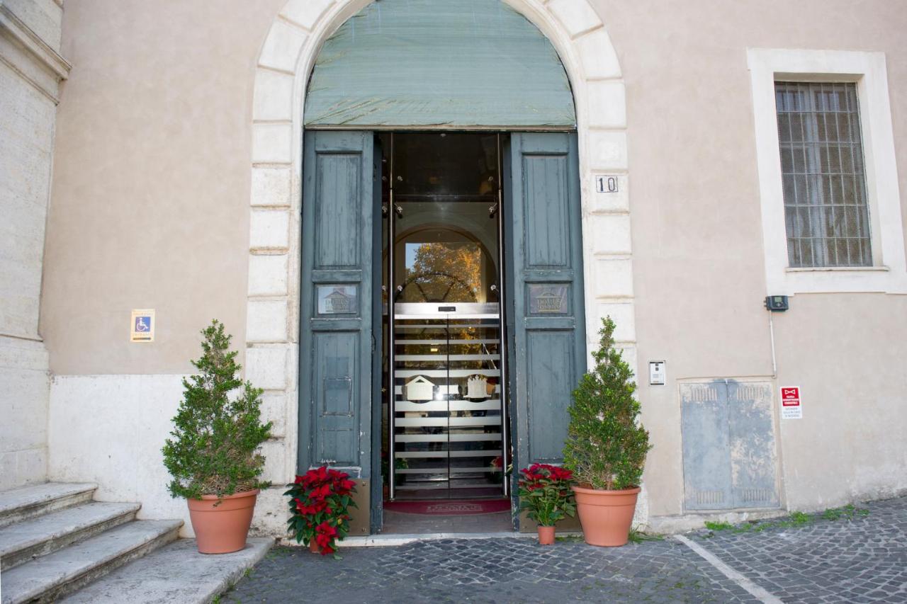 een ingang van een gebouw met twee potplanten bij Domus Sessoriana in Rome