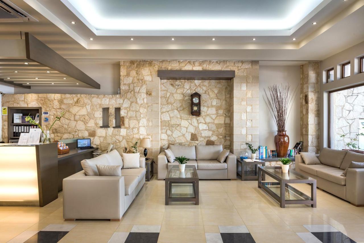 een woonkamer met banken en een stenen muur bij Elotis Suites in Agia Marina Nea Kydonias