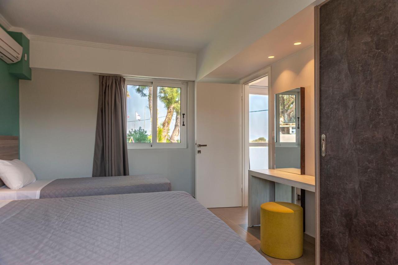 een hotelkamer met twee bedden en een raam bij Gelli Apartments in Kos-stad