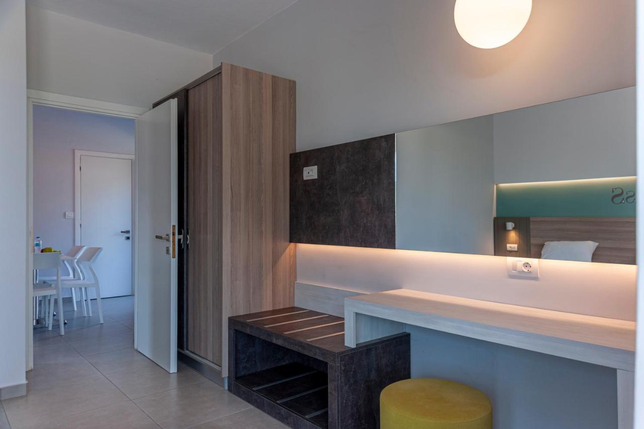 een kamer met een toonbank, een bankje en een spiegel bij Gelli Apartments in Kos-stad