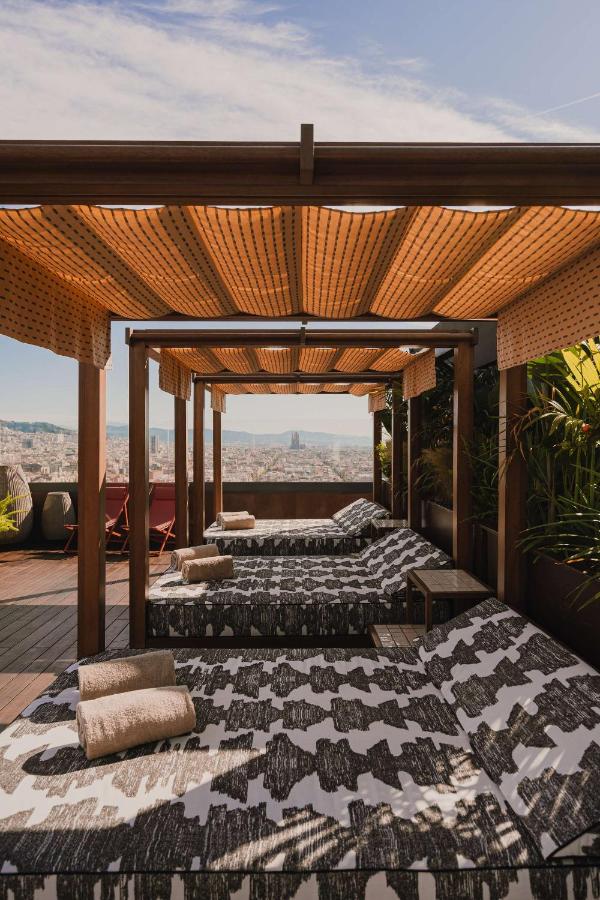Twee bedden op een dakterras met uitzicht over de stad. bij Nobu Hotel Barcelona in Barcelona