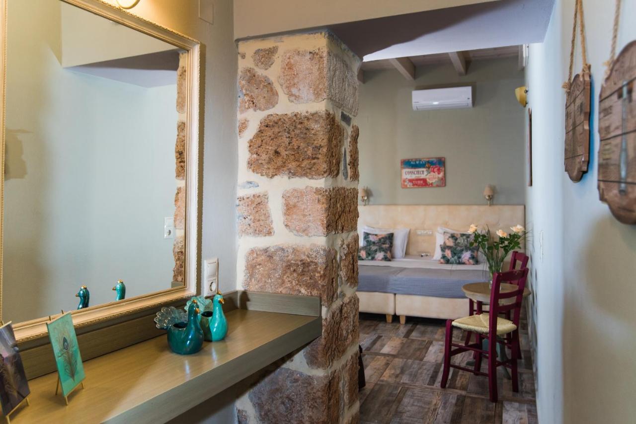 een kamer met een stenen muur en een spiegel bij Sarpidon Apartments in Malia
