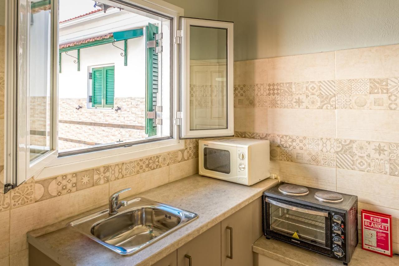 een keuken met een gootsteen en een magnetron bij Chandris Apartments in Kavos