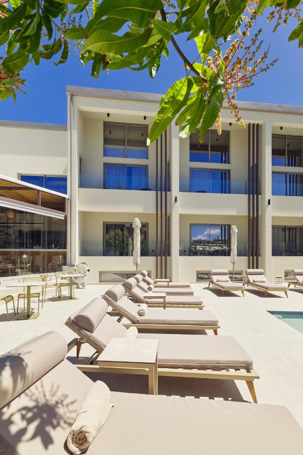 een rij loungestoelen voor een gebouw bij Inea Sole Boutique Hotel in Kato Daratso