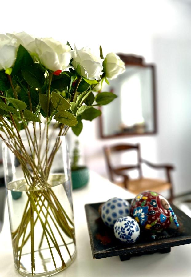een vaas met bloemen en paaseieren op een tafel bij Nostos Studios in Parikia