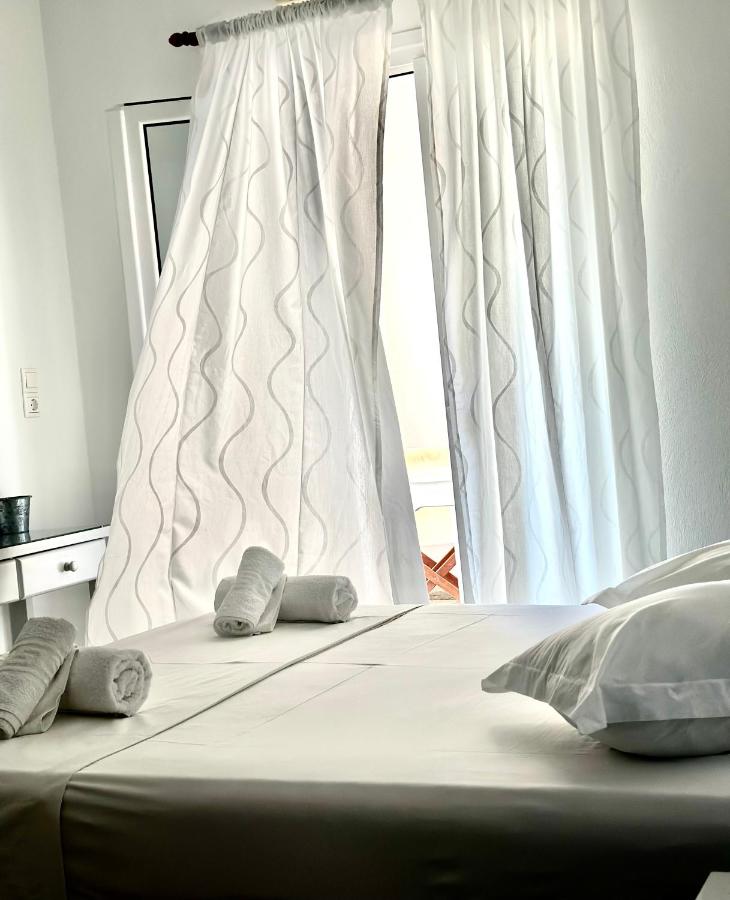 een bed met twee kussens voor een raam bij Nostos Studios in Parikia