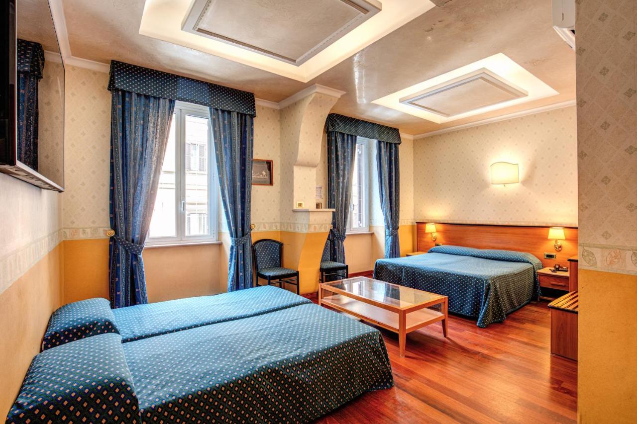 een hotelkamer met twee bedden en een tafel bij Hotel Verona Rome in Rome